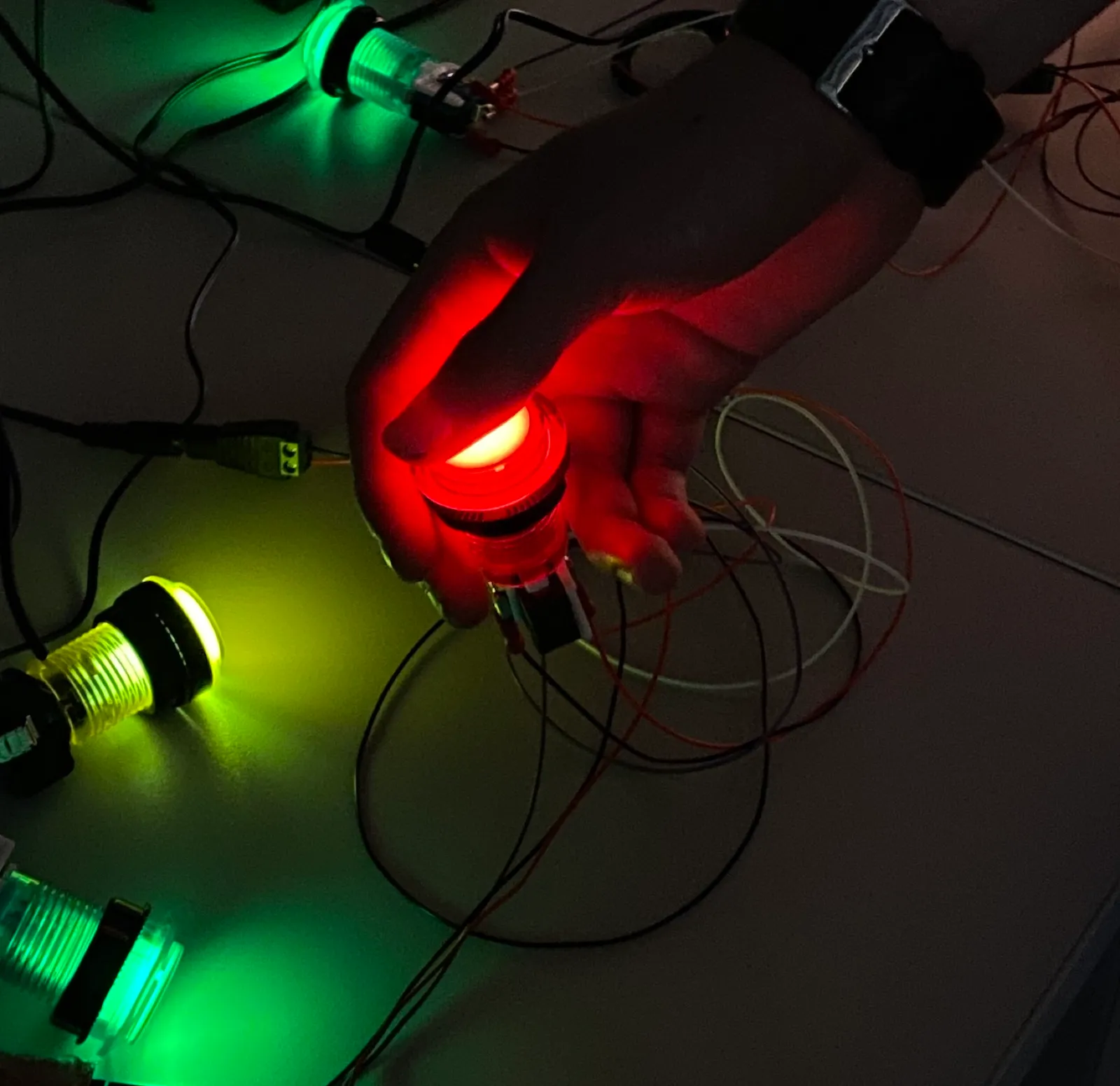 Illuminated arcade buttons being tested on the floor