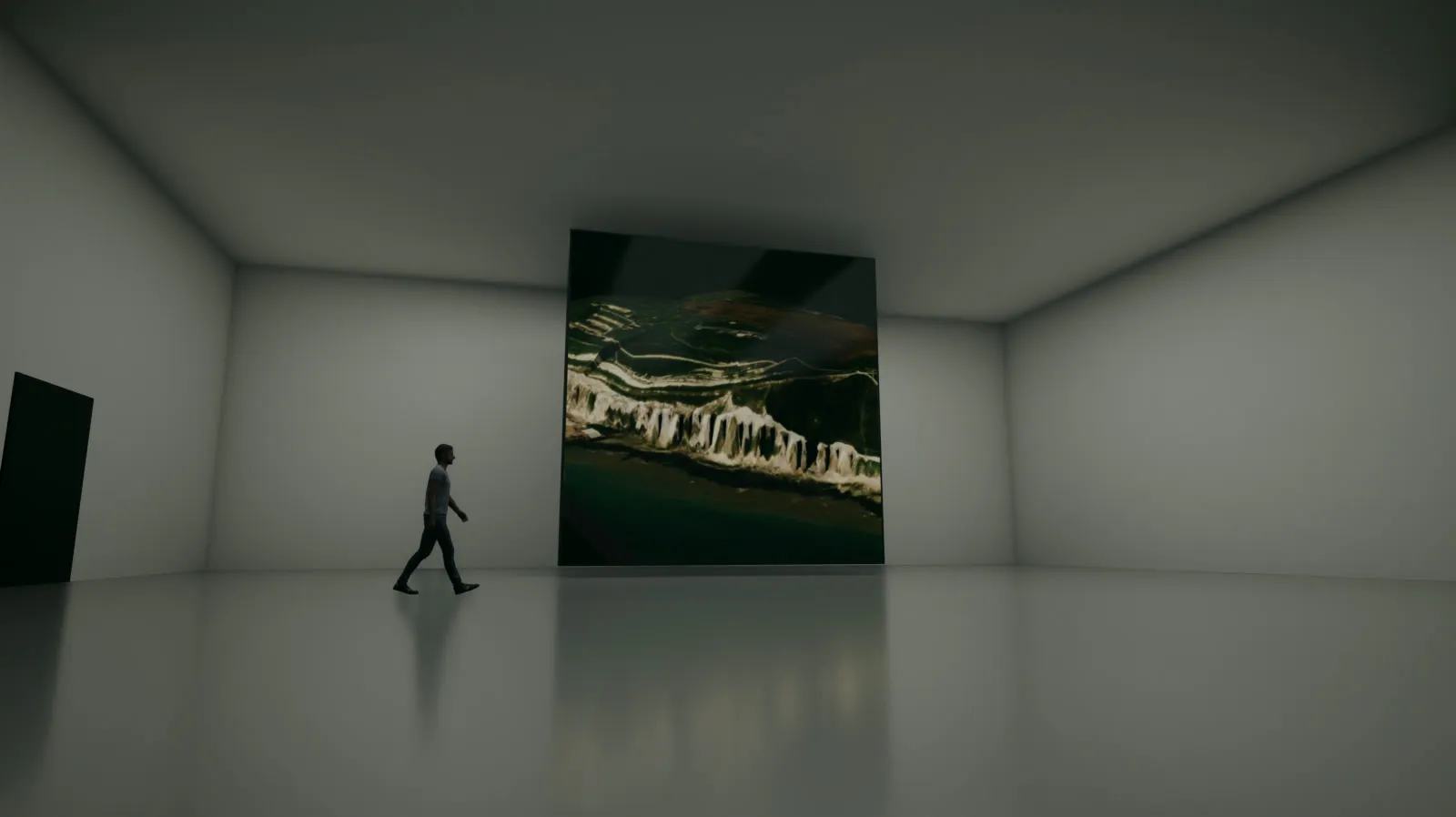 A white gallery with a polished floor, a large square screen showing the white cliffs at Dover from above, a man walking past it towards the door